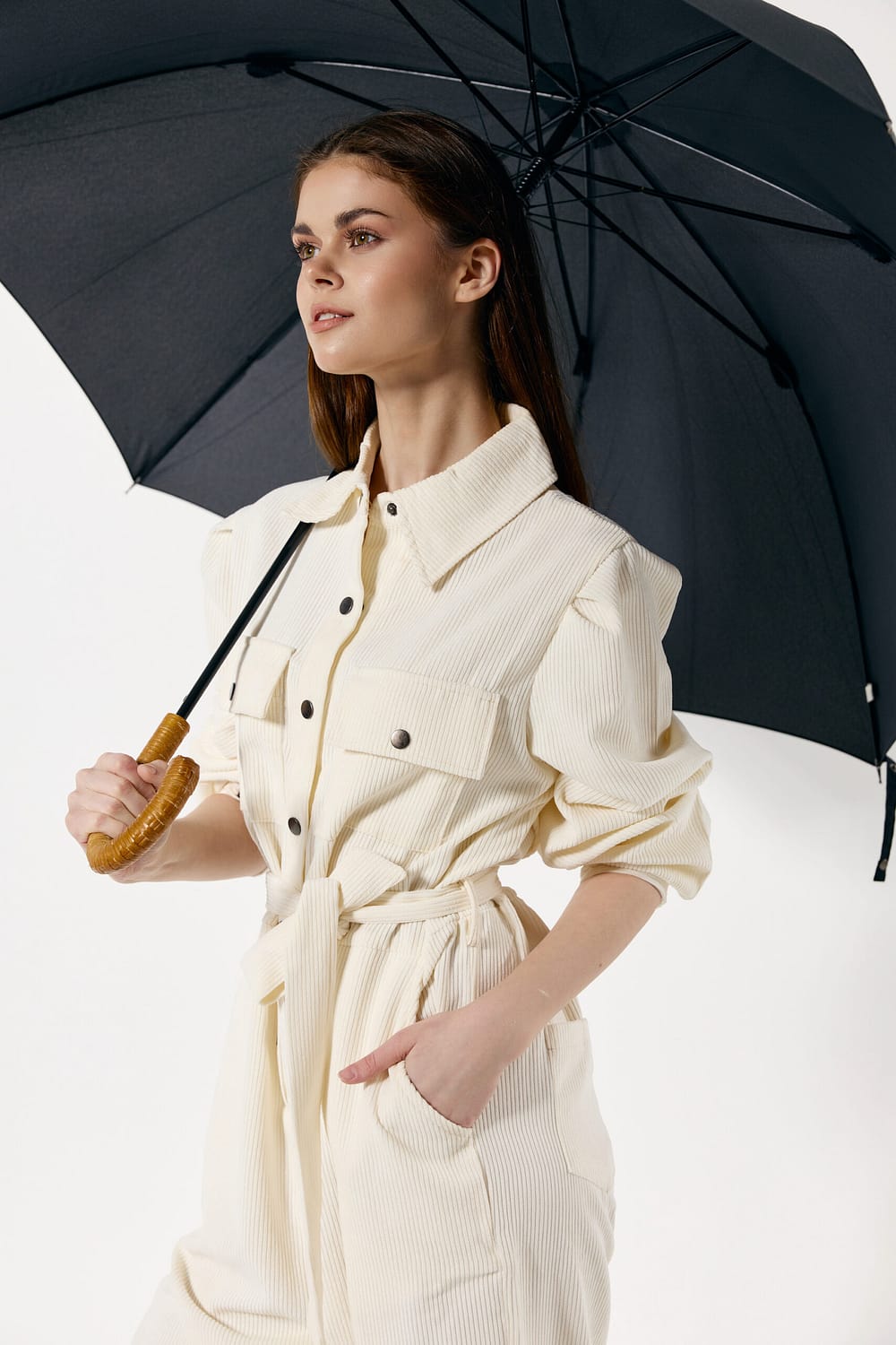 Woman in white suit open umbrella rainy weather