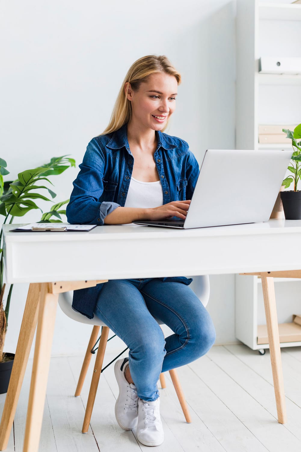 positive-young-woman-using-laptop-workplace