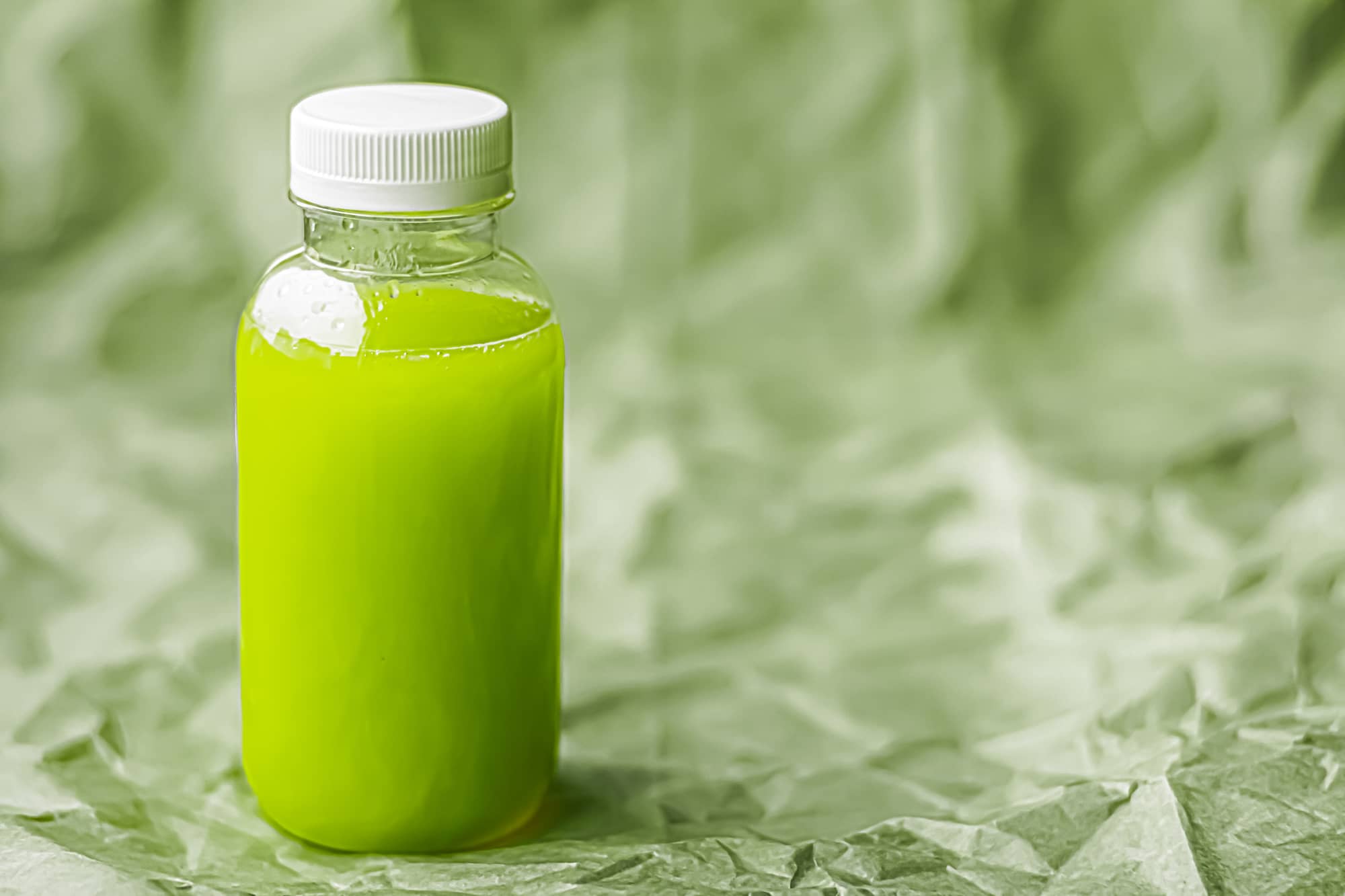 Fresh green juice in eco-friendly recyclable plastic bottle and packaging, healthy drink and food product